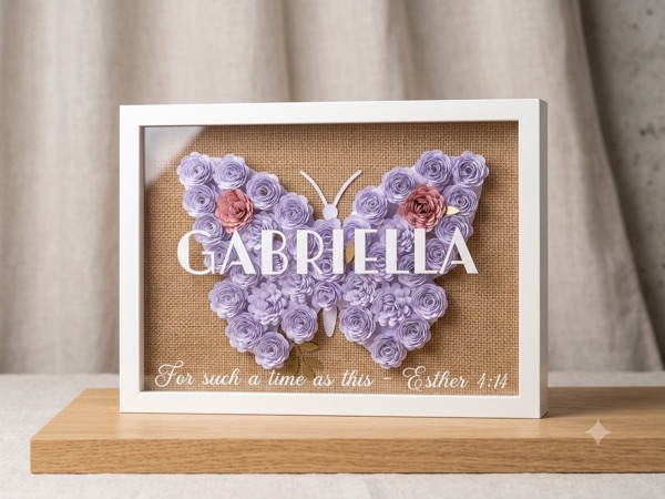 Shadow box with a butterfly of lilac paper flowers on hessian, lettered with the name Gabriella and: For such a time as this, Esther 4:14.